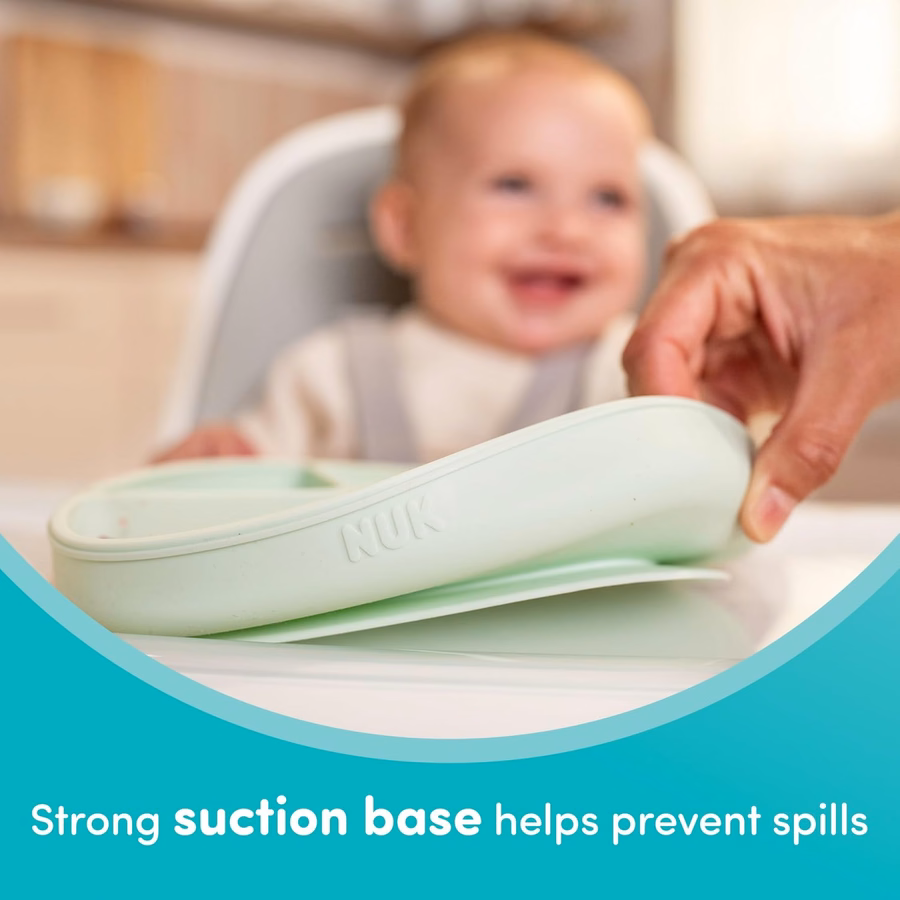 Ensemble de vaisselle bébé en silicone NUK, comprenant 1 assiette, 1 bol, 1 tasse et 1 cuillère. Système de ventouses résistant pour éviter les renversements. Compatible micro-ondes. Sans BPA.
